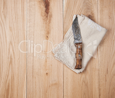old knife and dishcloth on a wooden background
