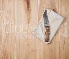 old knife and dishcloth on a wooden background