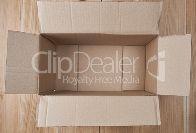 open empty rectangular box of brown cardboard on a wooden backgr