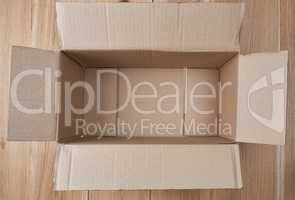 open empty rectangular box of brown cardboard on a wooden backgr