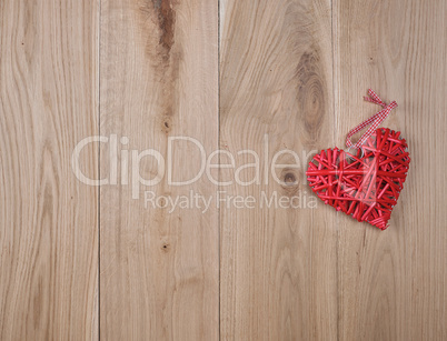 wooden background of oak boards and a red wicker heart