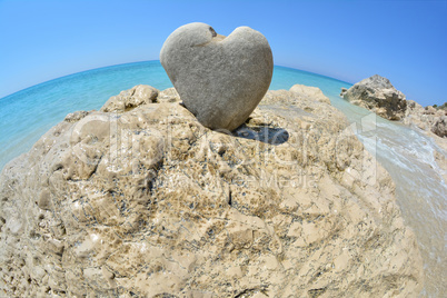 Heart shaped stone on white rock