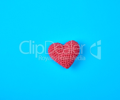 small red knitted heart on a blue background