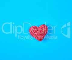 small red knitted heart on a blue background
