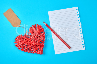 wooden wicker red heart and an empty white sheet of notepad