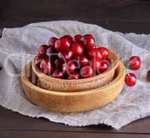 ripe red cherries in a brown wooden bowl