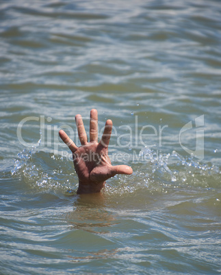 man's hand sticks out from the water in the middle of the ocean