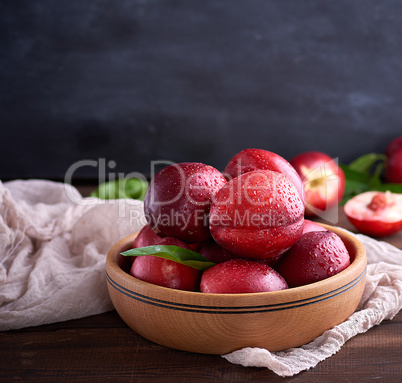 ripe peaches nectarine in a brown wooden bowl