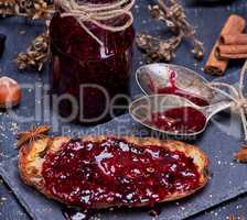 toast with raspberry jam and empty jam jar with an iron spoon