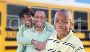 Proud African American Parents and Young Boy Near School Bus