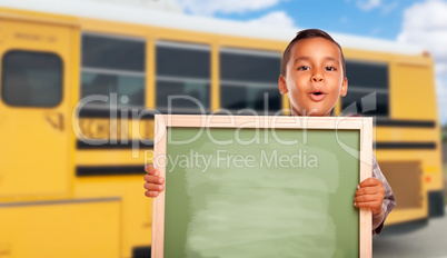 Young Hispanic Boy with Blank Chalkboard Near School Bus