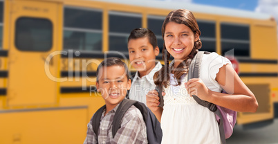 Young Hispanic Girl and Boys Walking Near School Bus
