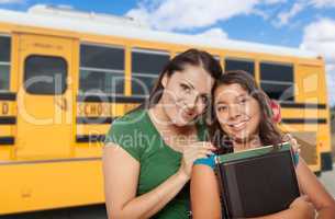 Hispanic Mother and Daughter Near School Bus.