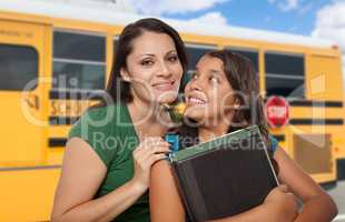 Hispanic Mother and Daughter Near School Bus.