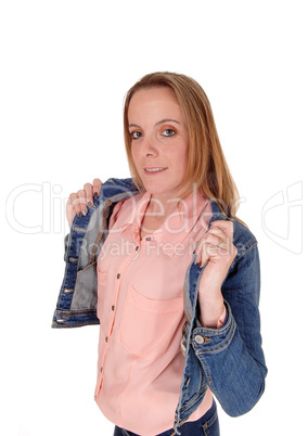 Young blond woman standing holding her jeans jacket