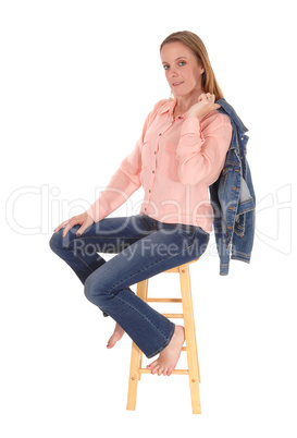 Woman sitting on chair, jacket over shoulder
