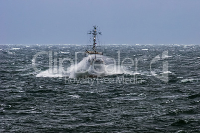 Military ship at sea during a storm.