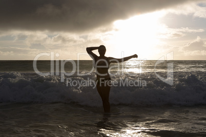 Beach girl in the ocean at sunset