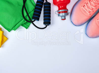 pink sports sneakers and a red water bottle, black jump rope
