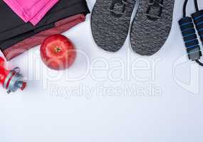 black textile shoes and other items for fitness on a white backg