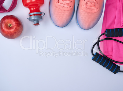pink sports sneakers and a red water bottle, black jump rope
