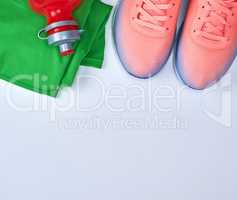pink sports sneakers and green clothes on a white background