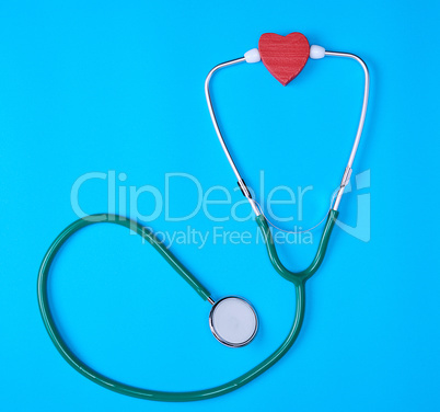 green medical stethoscope and red wooden heart