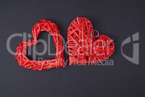 two wicker red hearts on a black background