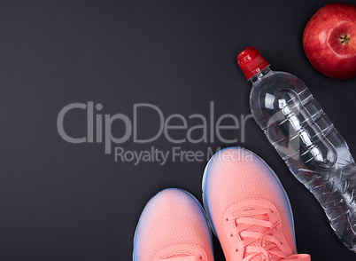 pink sports sneakers and a  water bottle