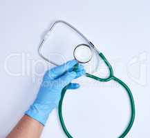 green medical stethoscope in human hand