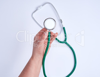 green medical stethoscope in human hand