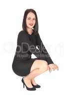 Pretty woman crouching on floor in a dress