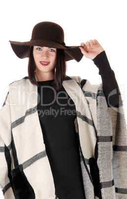 Lovely woman standing in black dress with a poncho and hat