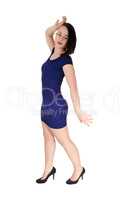 Woman standing in a blue tight dress one hand up
