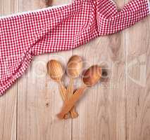 three empty wooden spoons on a red kitchen towel