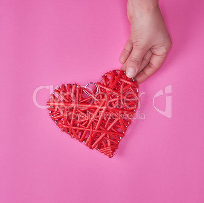 wooden wicker red heart in a female hand