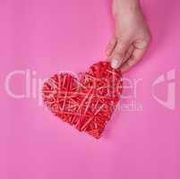 wooden wicker red heart in a female hand
