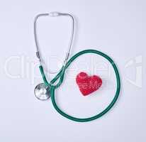 green medical stethoscope and red  heart