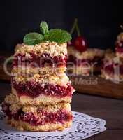 baked square pieces of cake with cherries