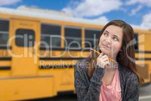Young Female Teen Student Near School Bus