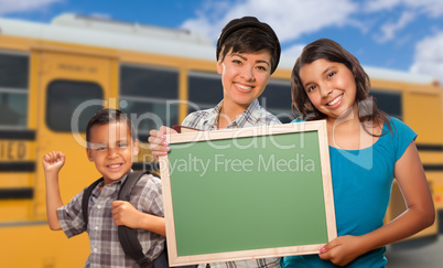 Young Mixed Race Students with Blank Chalkboard Near School Bus