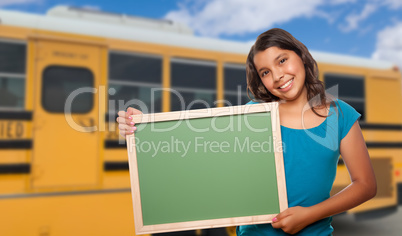 Young Female Hispanic Student with Blank Chalkboard Near School