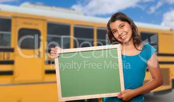 Young Female Hispanic Student with Blank Chalkboard Near School