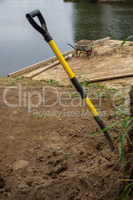 Wheelbarrow and shovel for construction in site building area.