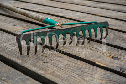 Old rake on the wooden planks.