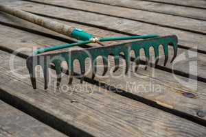 Old rake on the wooden planks.