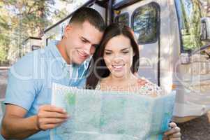 Young Military Couple Looking at Map In Front of RV