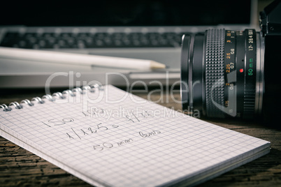 Closeup of a camera and a written notebook