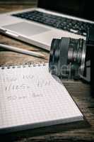 Closeup of a written notebook and a camera