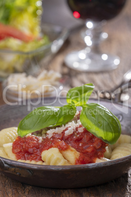 Nahaufnahme von Gnocchi mit Sauce auf Holz